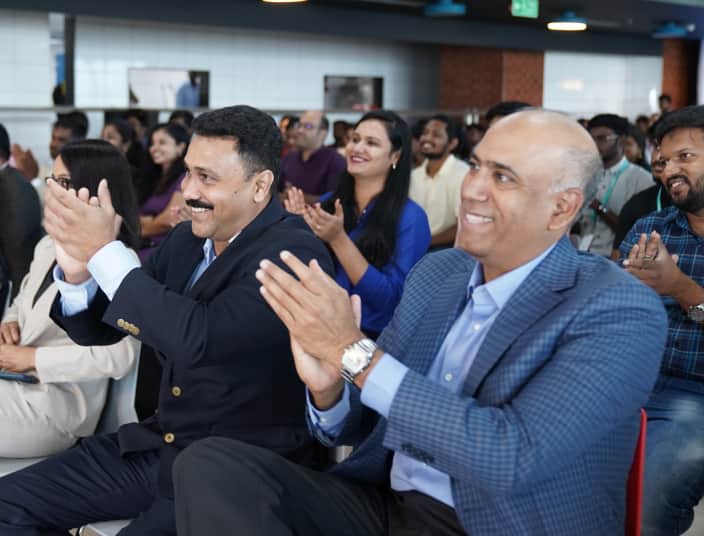 Tekion employees in India applauding during a global company presentation on automotive cloud innovation