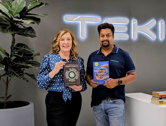 Tekion employees holding books during a company culture or learning session